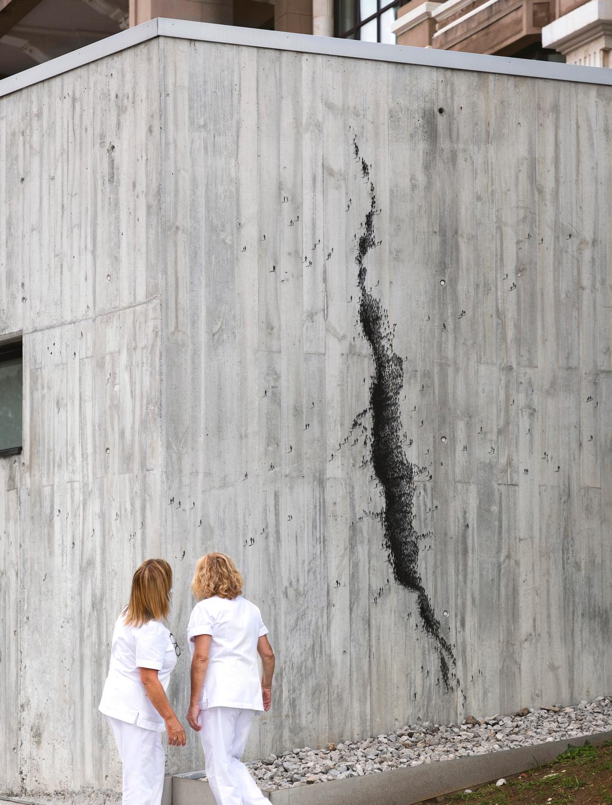  Social Distancing: The artwork creates an illusion of a widening crack made of numerous human silhouettes. Pejac used the crevice to represent the trauma and loss caused by the COVID-19 pandemic while depicting the human struggle to escape it. (Courtesy of ©PEJAC, @<a href="https://www.instagram.com/pejac_art/">pejac_art</a>)
