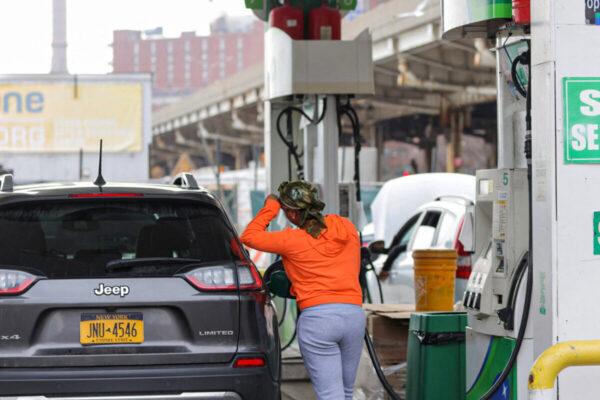 A person pumps gas at a gas station as fuel prices surged in New York, on March 7, 2022. (Andrew Kelly/Reuters)