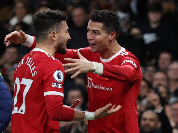 Manchester United's Cristiano Ronaldo celebrates scoring their third goal with Alex Telles during the Premier League match between Manchester United and Tottenham Hotspur at Old Trafford in Manchester, Britain, on March 12, 2022. (Phil Noble/Reuters)