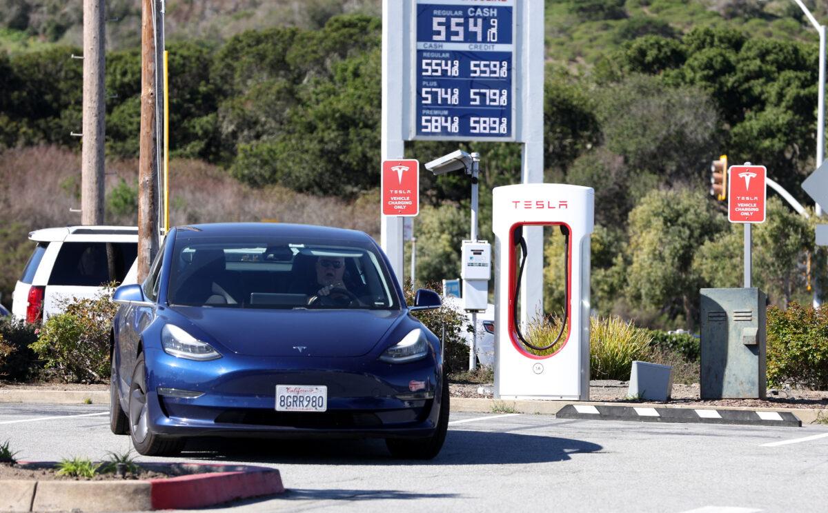 A Tesla car leaves a Supercharger after recharging its battery in San Bruno, Calif., on March 10, 2022. (Justin Sullivan/Getty Images)