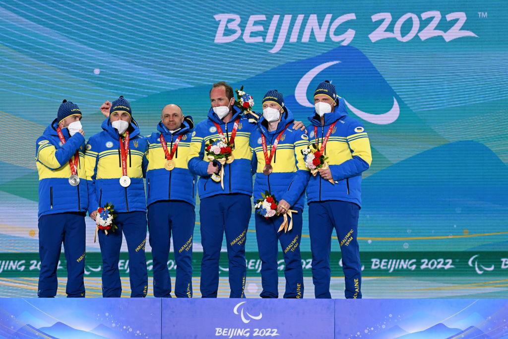 Gold medallist Vitalii Lukianenko of Team Ukraine (C) and guide Borys Babar, Silver medallist Anatolii Kovalevskyi of Team Ukraine (L) and guide Oleksandr Mukshyn, and Bronze medallist Dmytro Suiarko of Team Ukraine (R) guide Oleksandr Nikonovych celebrate during the Men’s Para Biathlon Middle Distance Vision Impaired medal ceremony at the Zhangjiakou Medals Plaza on day four of the Beijing 2022 Winter Paralympics in Zhangjiakou, China, on March 8, 2022. (Zhe Ji/Getty Images for International Paralympic Committee)