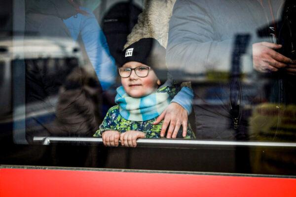 A Ukrainian refugee boy looks out a bus window after arriving in Poland through the Medyka border crossing on March 10, 2022. (Charlotte Cuthbertson/The Epoch Times)