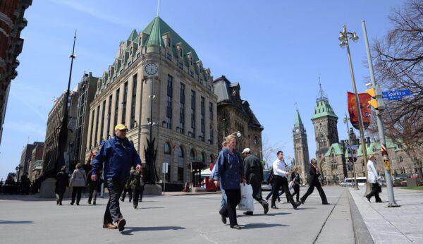 Pedestrians cross Elgin Street in view of the Peace Tower on Parliament Hill in Ottawa, in a file photo. (The Canadian Press/Sean Kilpatrick)