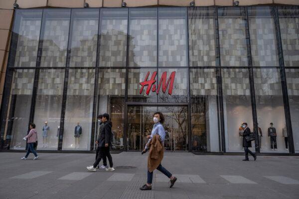 People walk by an H&M clothing store at a shopping area in Beijing, China, on March 30, 2021. (Kevin Frayer/Getty Images)