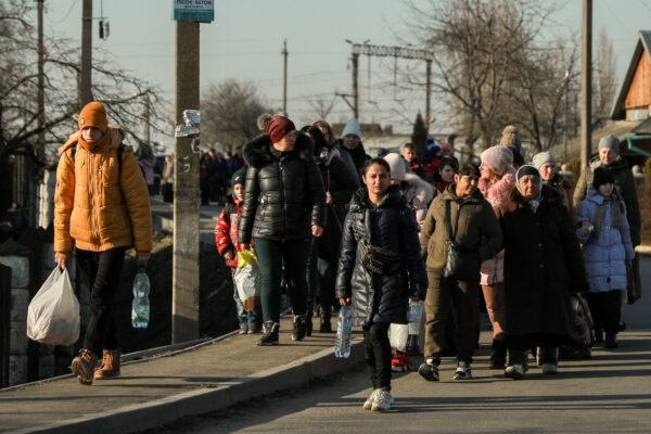 Ukrainians who have fled their homes walk from a train station to the border crossing into Medyka, Poland, from western Ukraine, on March 14, 2022. (Dan Skorbach/NTD)
