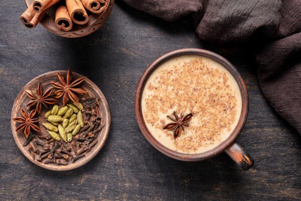 Masala tea chai latte traditional hot Indian sweet milk spiced drink, ginger, cinammon sticks, fresh spices blend, green cardamom, anise, organic infusion healthy wellness beverage By GreenArt/Shutterstock