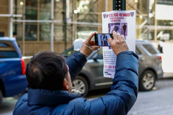 A man takes pictures of a bulletin posted by NYPD near the place where a homeless person was killed days earlier in lower Manhattan, New York, on March 14, 2022. (Eduardo Munoz Alvarez/AP Photo)