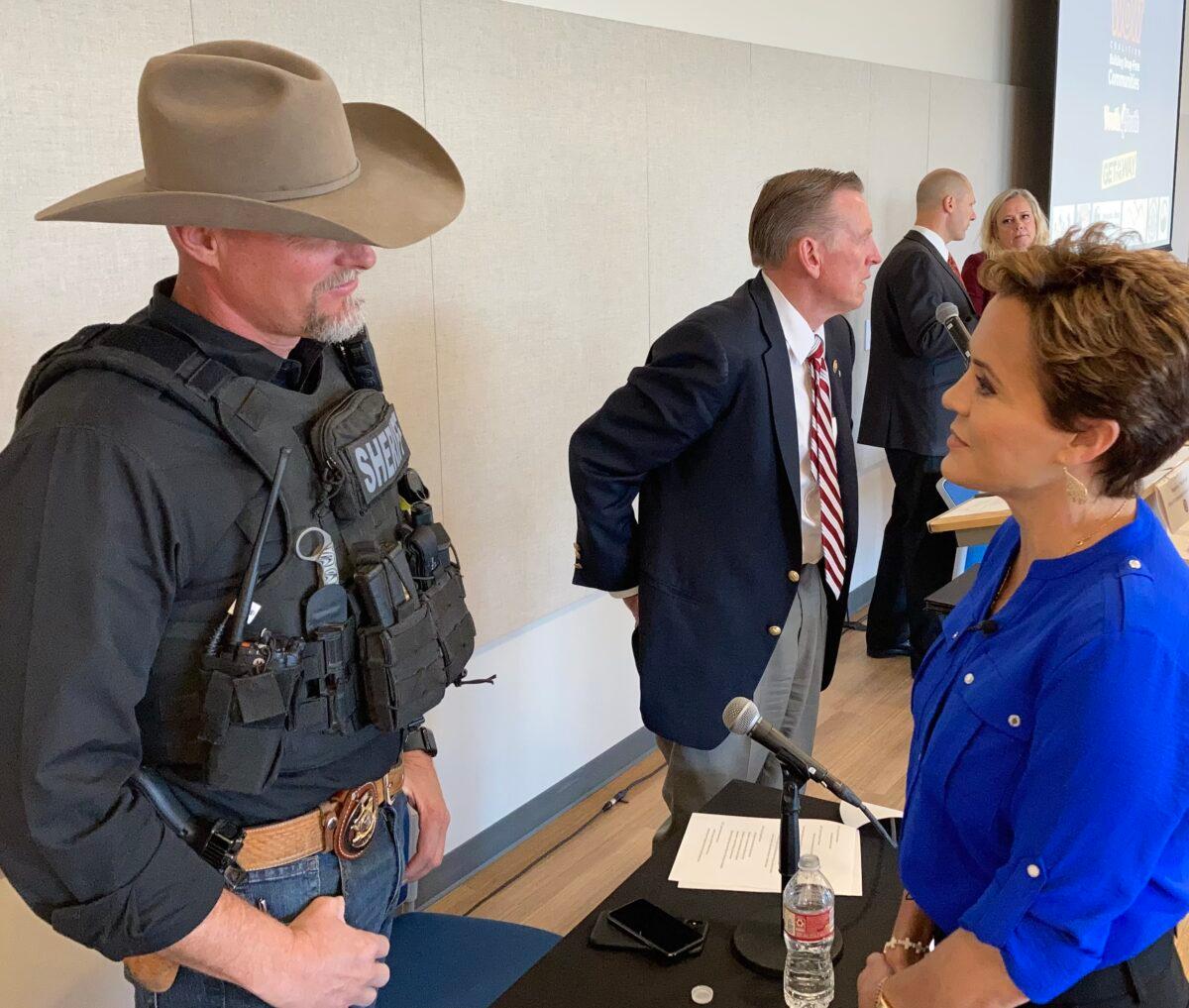 Pinal County Sheriff Mark Lamb speaks with Kari Lake, the Republican candidate for Arizona governor, during a roundtable discussion of the fentanyl crisis in Goodyear, Ariz., on March 14, 2022. (Allan Stein/The Epoch Times)