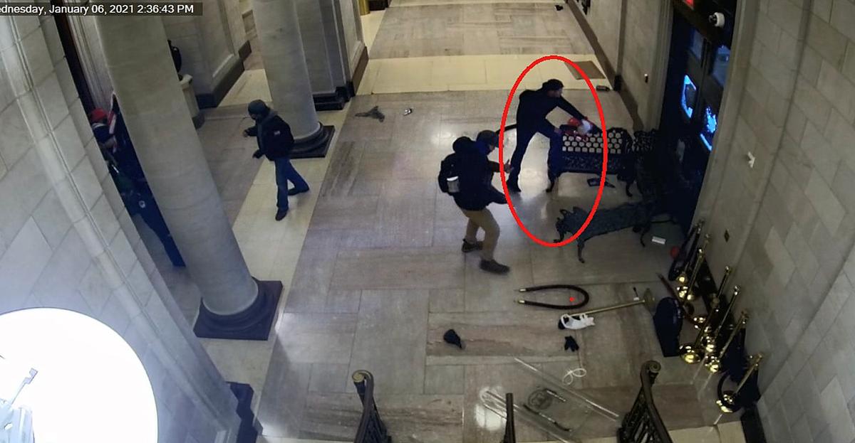 Jeffrey Alexander Smith removes metal benches from the east Rotunda entrance at the U.S. Capitol on Jan. 6, 2021. (U.S. Department of Justice/Screenshot via The Epoch Times)