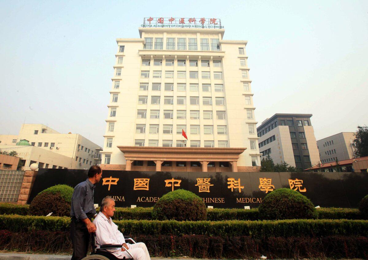 People pass the China Academy of Chinese Medical Sciences in Beijing on Oct. 6, 2015. (STR/AFP via Getty Images)