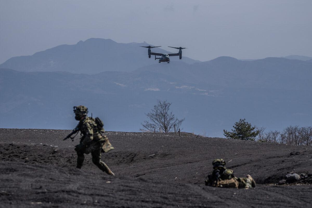 A U.S. Marine Corp Osprey comes in to land next to soldiers from Japan's 1st Amphibious Rapid Deployment Brigade during an exercise with the U.S. 31st Marine Expeditionary Unit in Gotemba, Japan, on March 15, 2022. (Carl Court/Getty Images)