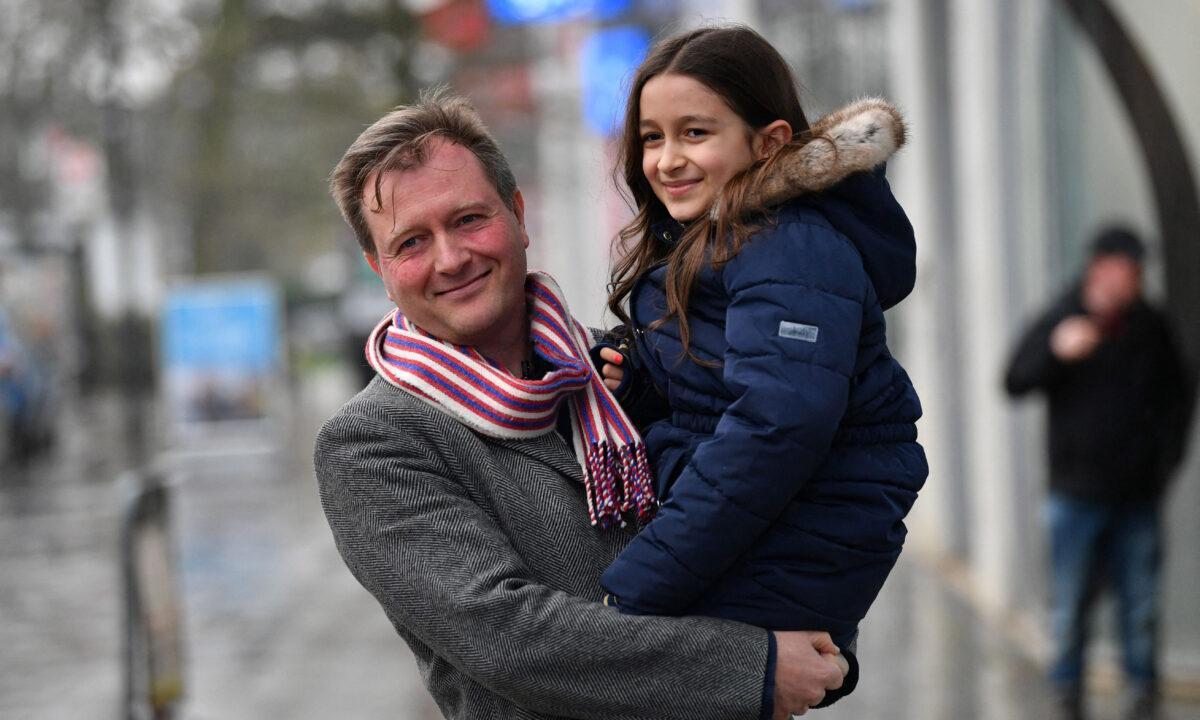 Richard Ratcliffe (L), husband of Nazanin Zaghari-Ratcliffe, a British-Iranian held in Iran since 2016, poses for pictures with their daughter Gabriella (R) in his arms, following a press briefing outside his house in London, on March 16, 2022. (Justin Tallis/AFP via Getty Images)