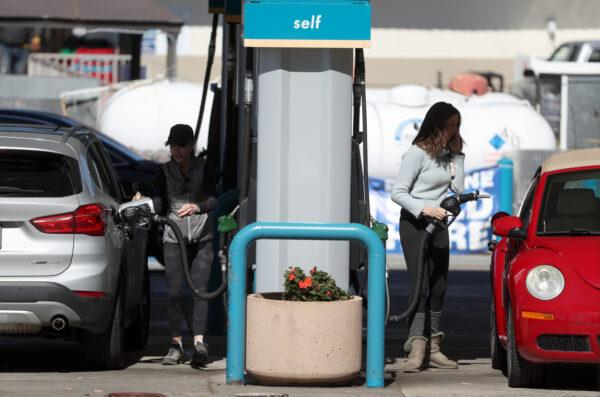 Customers pump gas into their cars at a gas station in Mill Valley, Calif., on Feb. 23, 2022. (Justin Sullivan/Getty Images)