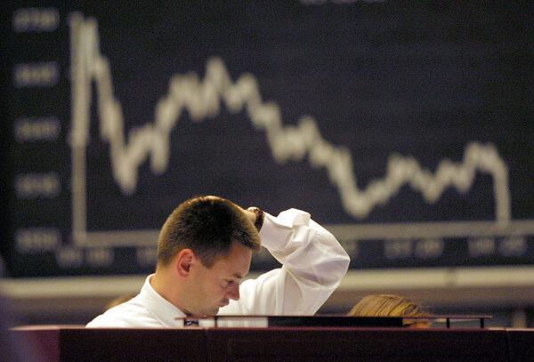 A trader rubs his head at the Frankfurt stock exchange in Germany on July 25, 2002. (Sean Gallup/Getty Images)