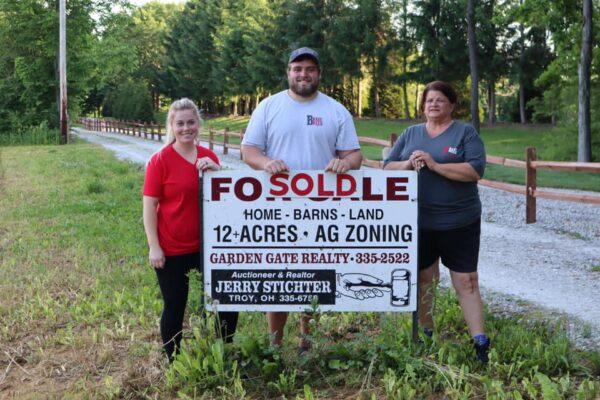 Tackling a dream: NFL Lineman Wes Martin (center) with his wife, Bailey (L) and mother, Rhonda Martin (R) on the property they purchased in West Milton, Ohio in 2018 for a dog rescue. Brave Breed Rescue currently houses 15 dogs available for adoption. (Photo courtesy Rhonda Martin)