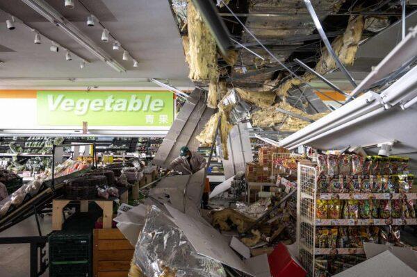 A man cleans the debris of a damaged ceiling at a supermarket in Shiroishi, Miyagi prefecture, on March 17, 2022, after a 7.4 magnitude earthquake jolted eastern Japan the night before. (Charly Triballeau/AFP via Getty Images)