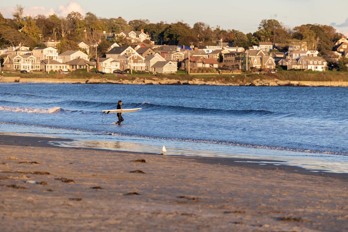 Surfer walking out into the water on Easton's Beach, Newport. (Peter Wood)