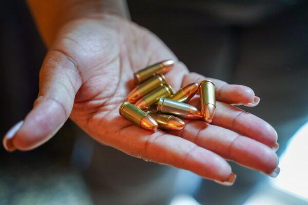 Jessica Luckett holds training ammunition at her home in Chicago, on Feb. 23, 2022. She uses them to practice at local gun ranges. (Cara Ding/The Epoch Times)