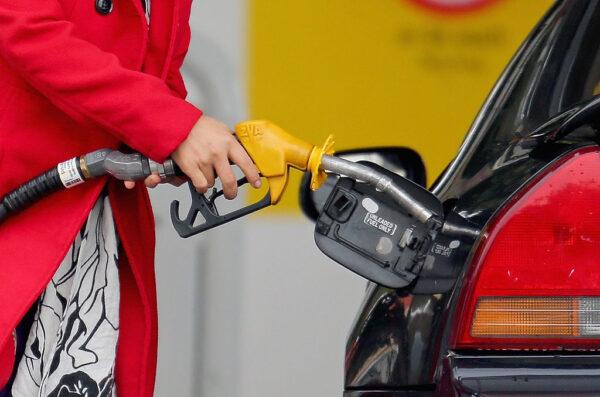 A woman uses a fuel dispenser to fill her car up with petrol at a petrol station in Melbourne, Australia, on July 23, 2013. (Scott Barbour/Getty Images)