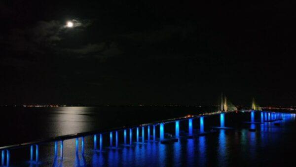 The Worm Moon rises near an illuminated Bob Graham Sunshine Skyway bridge in St. Petersburg, Fla., on March 17, 2022, in a still from video. (AP/Screenshot via The Epoch Times)