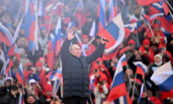 Russian President Vladimir Putin greets the audience as he attends a concert marking the eighth anniversary of Russia's annexation of Crimea at the Luzhniki stadium in Moscow, on March 18, 2022. (Ramil Sitdikov/Pool/AFP via Getty Images)