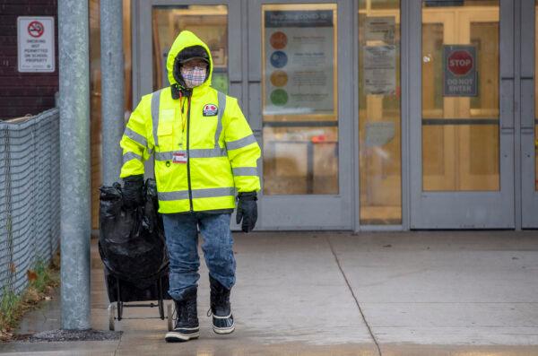 A masked crossing guard walks away from a school in Toronto on Nov. 30, 2020. (The Canadian Press/Frank Gunn)