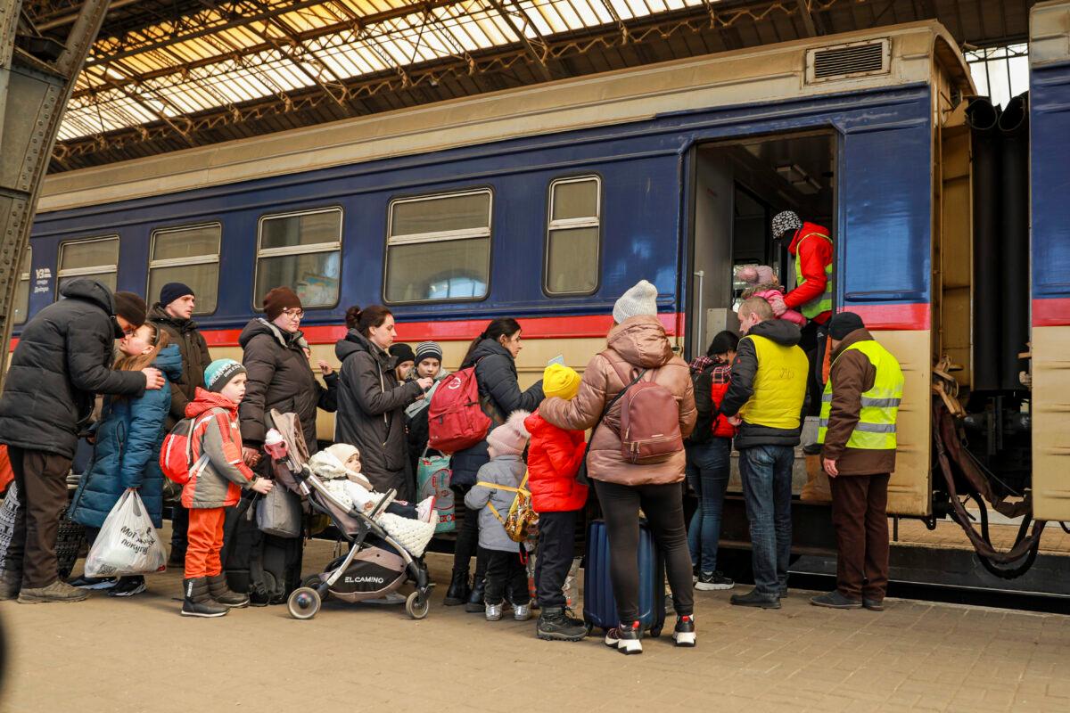 Ukrainian refugees prepare to board a train to Poland at the train station in Lviv, Ukraine, on March 18, 2022. (Charlotte Cuthbertson/The Epoch Times)