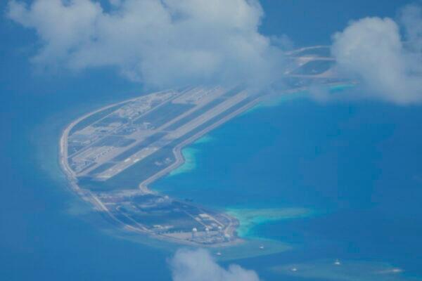 An airstrip made by China is seen beside structures and buildings on the man-made island on Mischief Reef at the Spratly group of islands in the South China Sea are seen on March 20, 2022. (AP Photo/Aaron Favila)