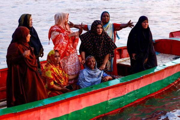 Relatives of the victims mourn as a ferry sank after colliding with a sand carrier ship in Narayanganj, Bangladesh, on March 20, 2022. (Mohammad Ponir Hossain/Reuters)