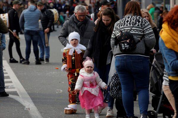 People walk home, after an incident at a carnival, in Strepy-Bracquenies, Belgium, on March 20, 2022. (Olivier Matthys/AP Photo)