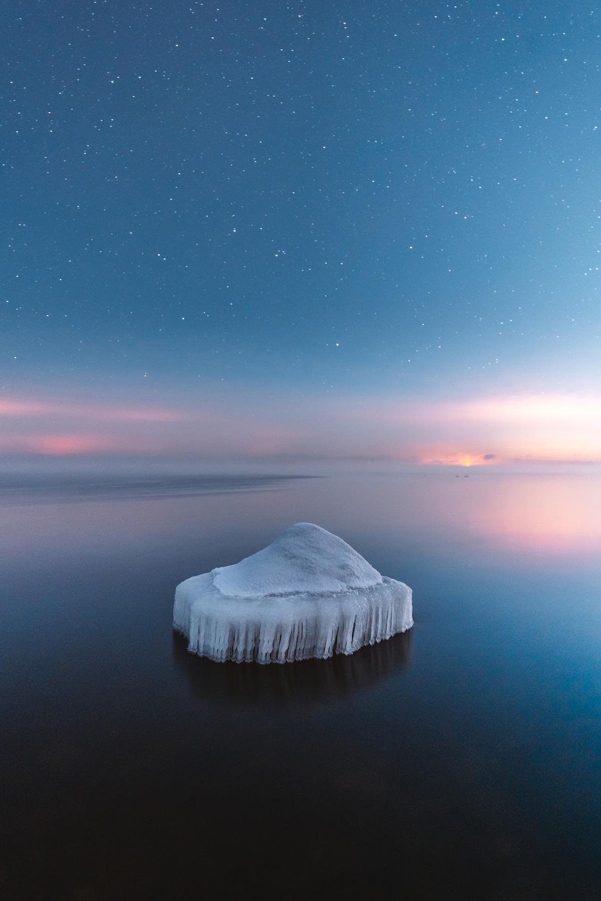 "Frozen Rock" by Damon Beckford, Finland; "In January 2021 the temperature went down to -25°C on the south coast of Finland. I went to Emäsalo in the city of Porvoo to capture the freezing of the Baltic Sea. As the sea starts to freeze, it creates beautiful ice sculptures on the rocks, and a few days later the sea is frozen. The picture was shot at night with a slow shutter speed on extremely slippery ice." (© Damon Beckford, Finland, Winner, National Awards, Landscape, 2022 Sony World Photography Awards)