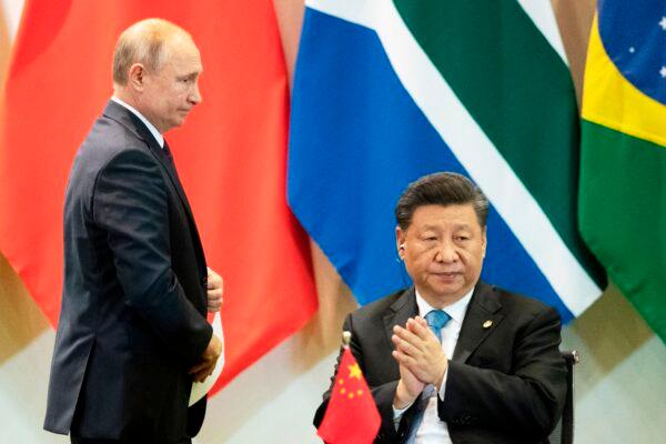 Chinese leader Xi Jinping (R) and Russian President Vladimir Putin attend a meeting with members of the Business Council and management of the New Development Bank during the BRICS summit in Brasília, Brazil, on Nov. 14, 2019. (Pavel Golovkin/Pool/AFP via Getty Images)