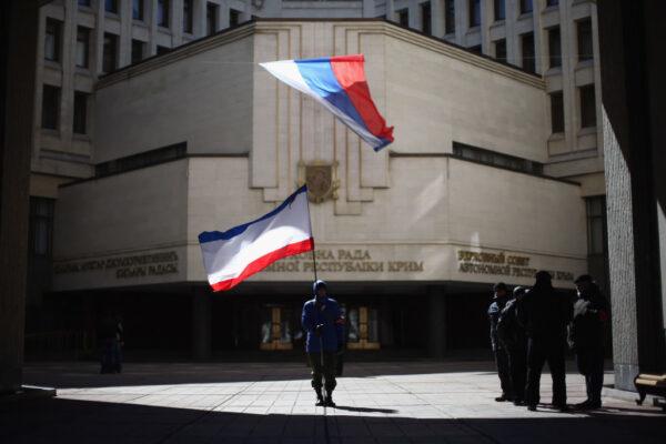 A man holds a Crimean flag in front of the Crimean parliament building in Simferopol, Ukraine, on March 17, 2014. (Dan Kitwood/Getty Images)
