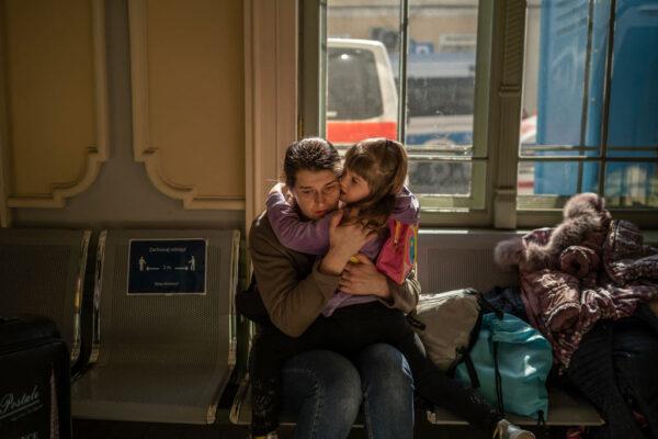 A Ukrainian evacuee hugs a child in the train station in Przemysl, near the Polish-Ukrainian border, on March 22, 2022. (Angelos Tzortzinis/AFP via Getty Images)
