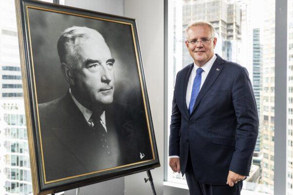 Prime Minister Scott Morrison poses for a photo standing next to a photograph of Sir Robert Menzies during a luncheon in Melbourne, Australia, on March 12, 2019. (AAP Image/Daniel Pockett)