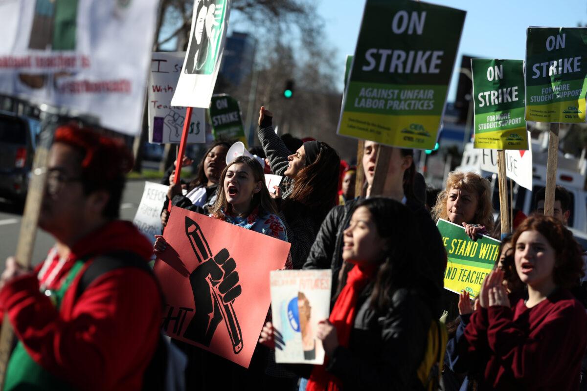 In this file photo, students and teachers carry signs as they picket outside of Oakland Technical High School in Oakland, Calif., on Feb. 21, 2019. (Justin Sullivan/Getty Images)