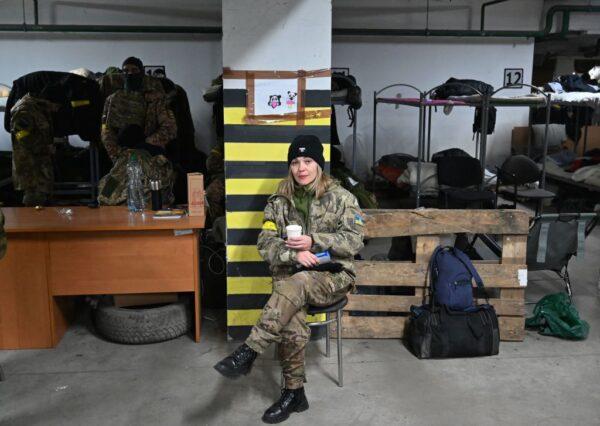 A female soldier of Territorial Defense Forces of Ukraine, the military reserve of the Armed Forces of Ukraine, drinks a cup of tea in an underground garage that has been converted into a training and logistics base in Kyiv, Ukraine, on March 11, 2022. (Sergei Supinsky/AFP via Getty Images)