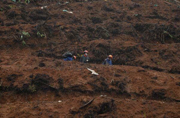 Rescue workers collect items at the site where China Eastern flight MU5375 crashed on March 21, near Wuzhou, in southwestern China’s Guangxi region, on March 24, 2022. (Noel Celis/AFP via Getty Images)