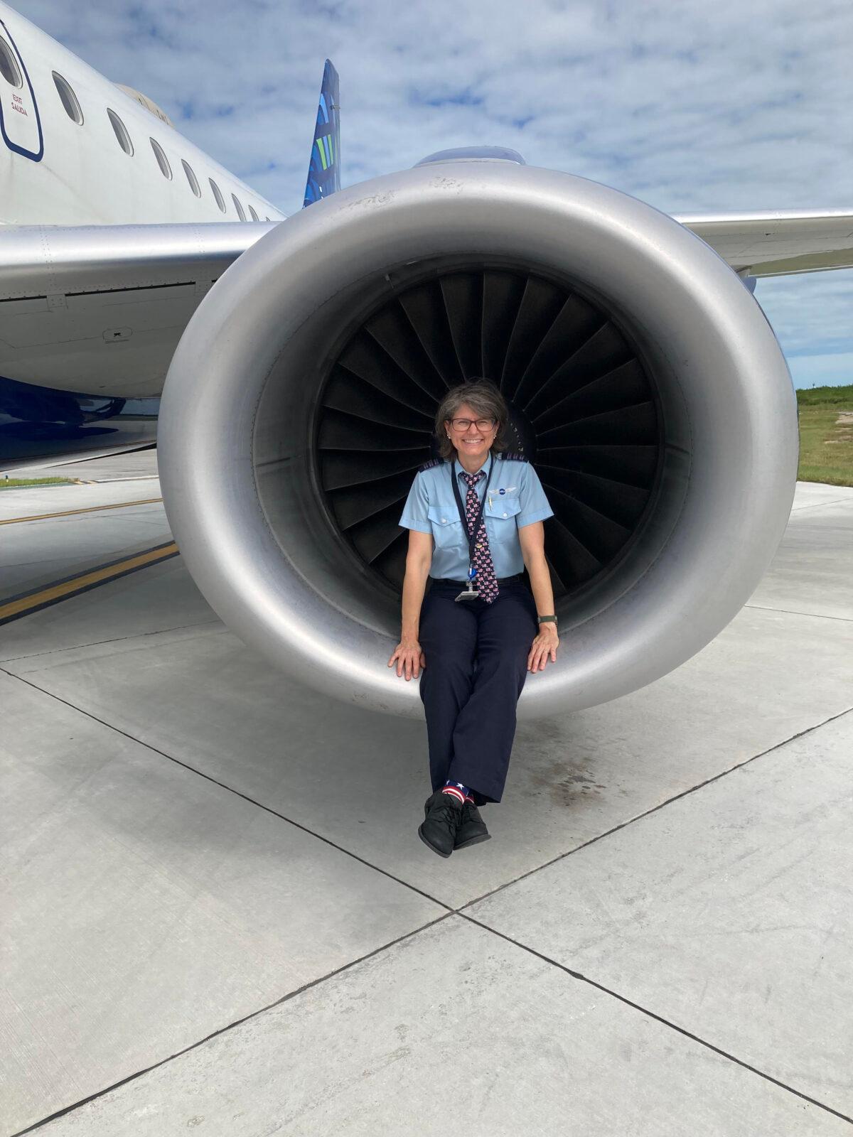 JetBlue Airways pilot Janviere Carlin sits on the edge of an engine turbine as the plane rests on the tarmac. (Courtesy of Janviere Carlin)