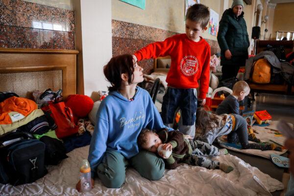 Alina Kaconskaya (L) with her three children at the train station in Lviv, Ukraine, on March 24, 2022. (Charlotte Cuthbertson/The Epoch Times)