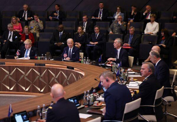 British Prime Minister Boris Johnson (L) and President Joe Biden (C) listen as NATO Secretary-General Jens Stoltenberg (C/R) addresses a North Atlantic Council meeting during an extraordinary summit at NATO Headquarters in Brussels on March 24, 2022. (Evelyn Hockstein/Pool/AFP via Getty Images)