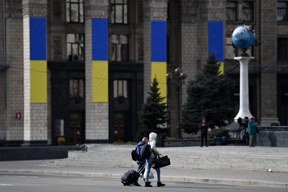 Men with bags and a suitcase walk in central Kyiv on Feb. 25, 2022. (Daniel Leal/AFP via Getty Images)