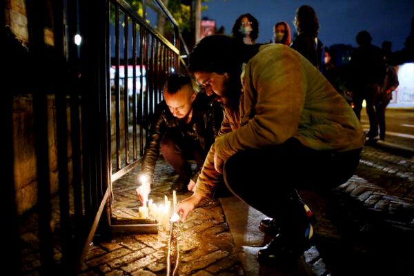 Fans of U.S. band Foo Fighters place lights in front of the hotel where the band's drummer Taylor Hawkins was found death in Bogota, Colombia, March 26, 2022. (Leonardo Munoz/AP Photo)
