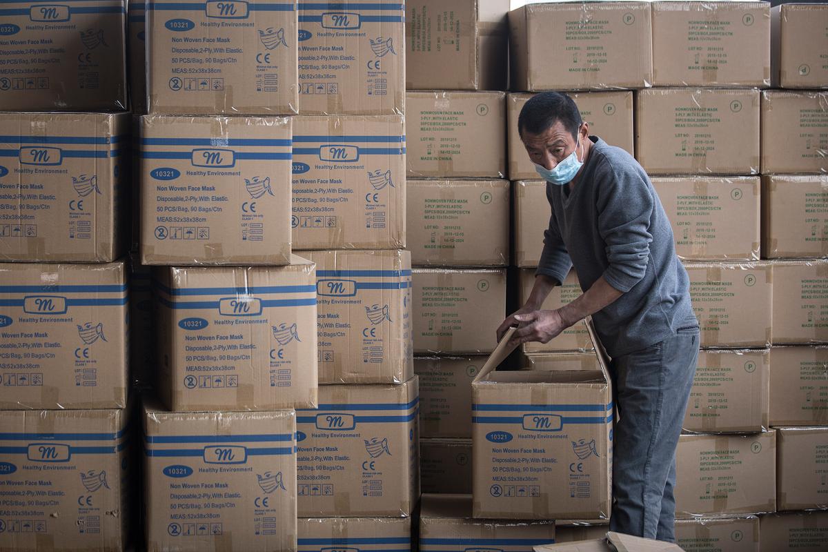 A worker transports and handles boxes with masks for export at Yangluo container port on the Yangtze River in Wuhan, Hubei Province, China, on April 12, 2020. (Getty Images)