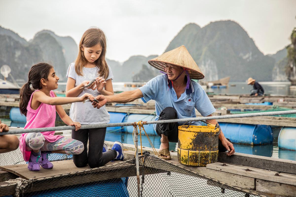 Children learn to fish with a local in Vietnam. (Photo courtesy of G Adventures.)