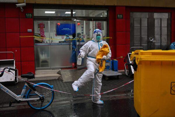 A health worker in protective gear crosses a line outside a hospital in a locked-down neighborhood in the Huangpu district of Shanghai, China on March 21, 2022. (Hector Retamal/AFP via Getty Images)