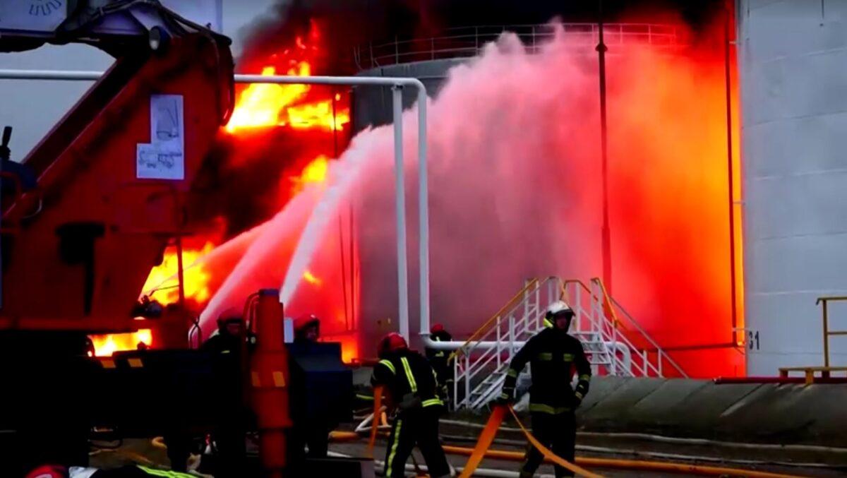 Firefighters work to extinguish a fire at a fuel storage facility in Lviv, Ukraine, on March 27, 2022. (Reuters/Screenshot via The Epoch Times)