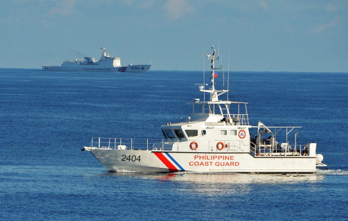 A Philippine coast guard ship (R) sails past a Chinese coastguard ship during an joint search and rescue exercise near Scarborough shoal, in the South China Sea on May 14, 2019. (Ted Aljibe/AFP via Getty Images)