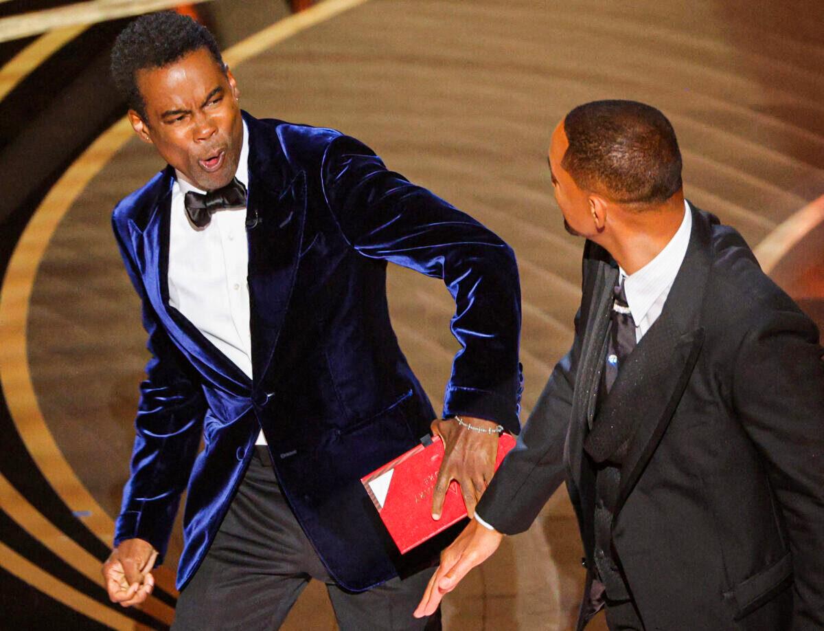 Will Smith (R) hit Chris Rock as Rock spoke on stage during the 94th Academy Awards in Hollywood, Los Angeles, Calif., on March 27, 2022. (Brian Snyder/Reuters)