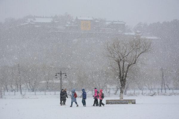 People visiting Beishan Park during snowfall in Jilin city in China's northeastern Jilin Province on March 13, 2019. (STR/AFP via Getty Images)